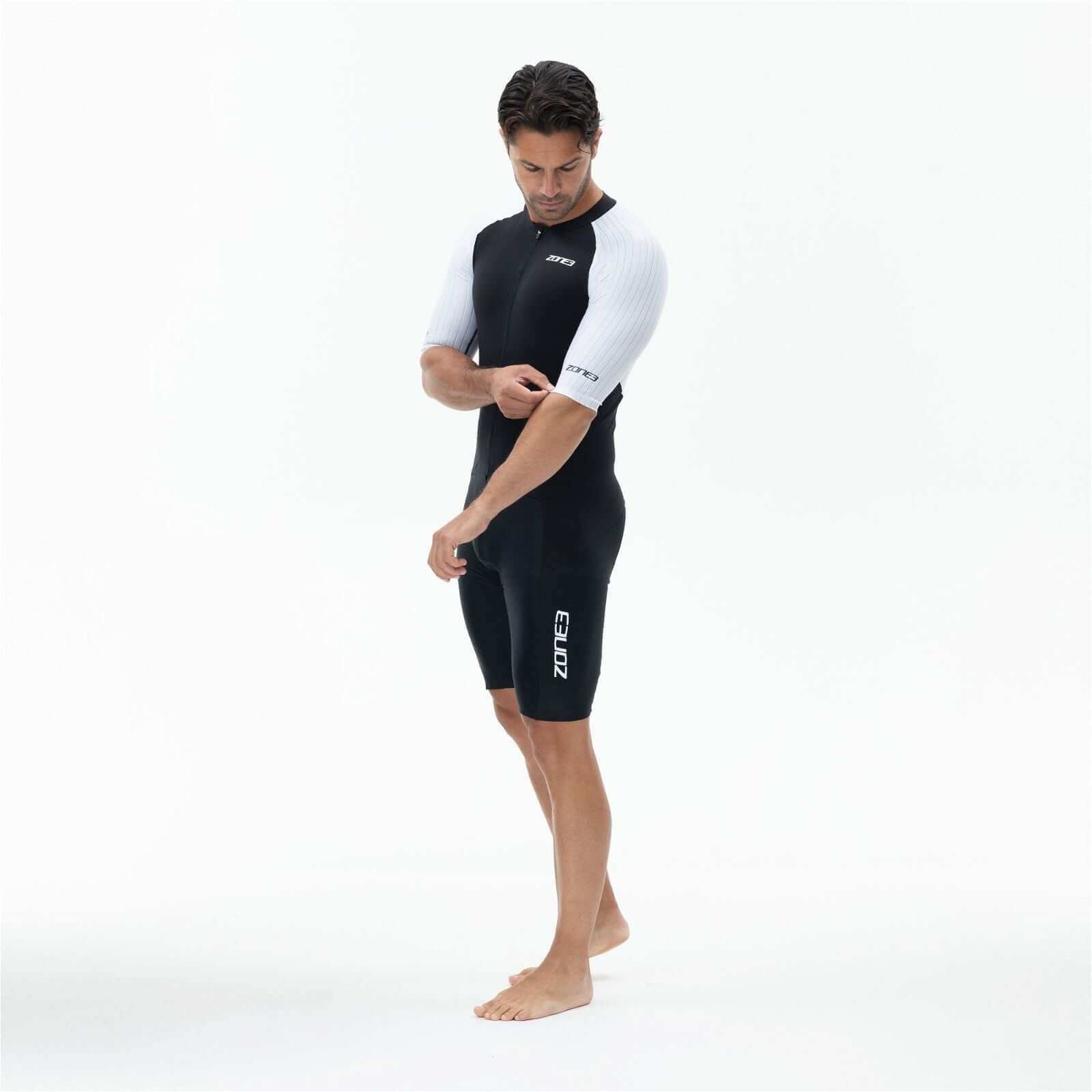 A man wearing the Zone3 Lava full zip short sleeve trisuit on a white background.