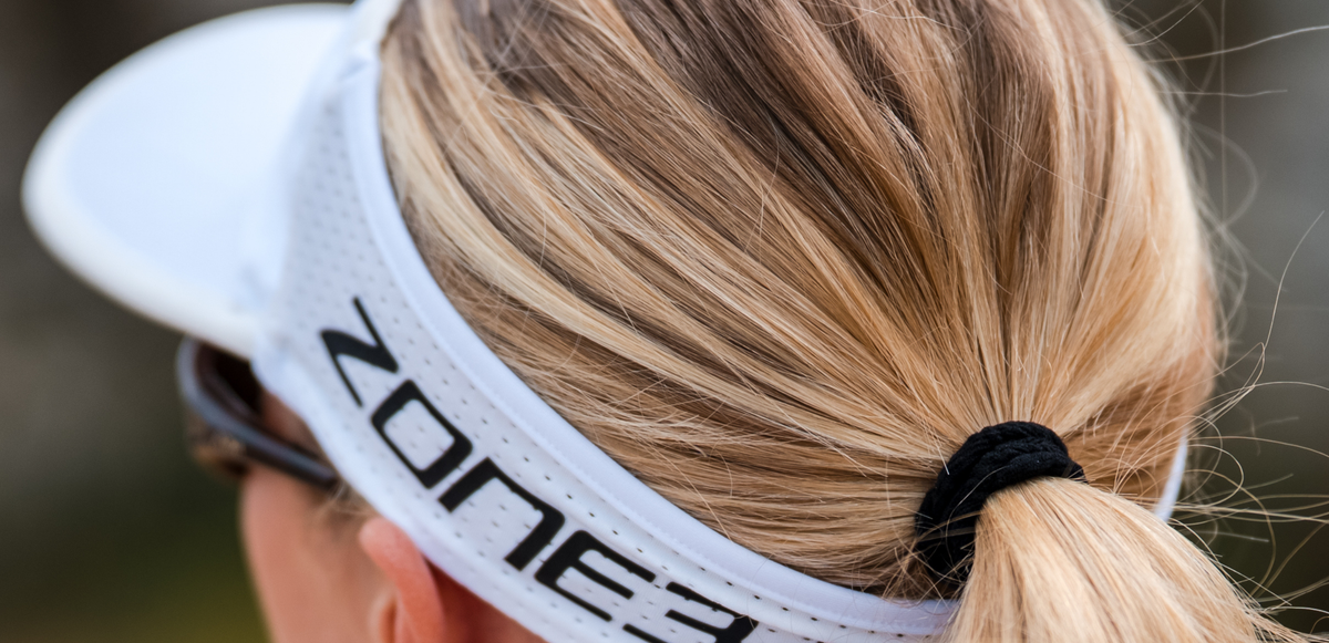 Close up of zone3 white running visor with a zone3 logo on a blurred background